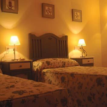 a hotel room with two beds and two lamps at Racó dels Torrats in Torre del Compte
