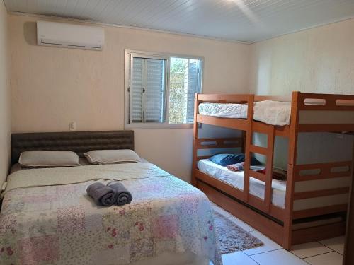 a bedroom with a bed and bunk beds and a window at Refúgio na Serra Gaúcha in Nova Petrópolis