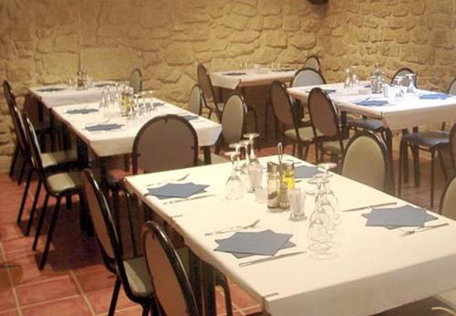 a room with tables and chairs with white tables andidents at Racó dels Torrats in Torre del Compte