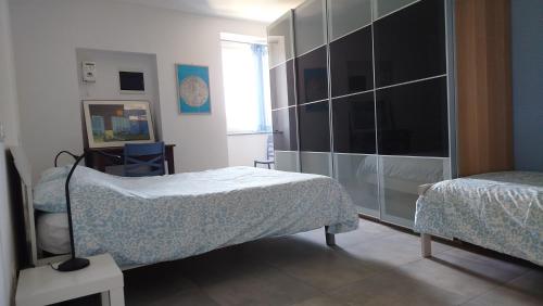 ein Schlafzimmer mit zwei Betten und einer großen Glaswand in der Unterkunft Buonacqua in Tavigliano