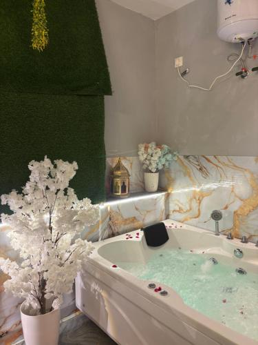 a bathroom with a bath tub with flowers in it at The terrace affair studio with jacuzzi in Gurgaon