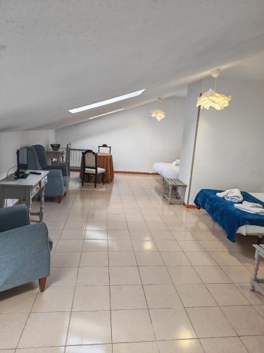 a room with two beds and a table and chairs at El Sueño del Infante in Guadalajara