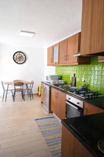 a kitchen with wooden cabinets and a table with chairs at Alojamento dos cagarros in São Sebastião