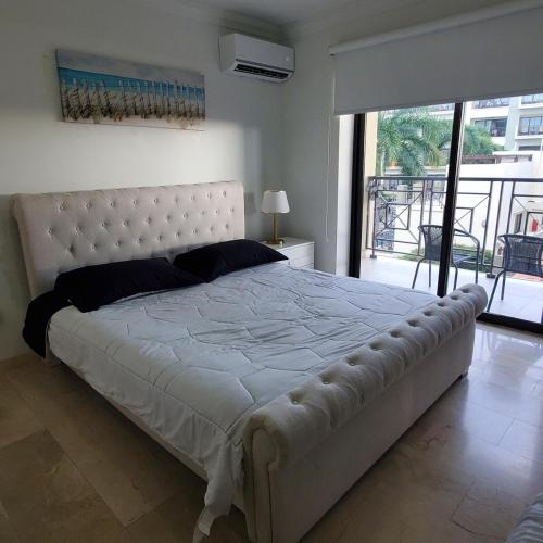a large white bed in a bedroom with a balcony at PALMARUBA 2bedroom condo in Palm-Eagle Beach