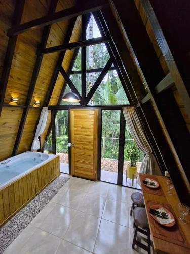 a large bathroom with a large window and a tub at Chalé a 500 metros do Pico Malwee in Jaraguá do Sul