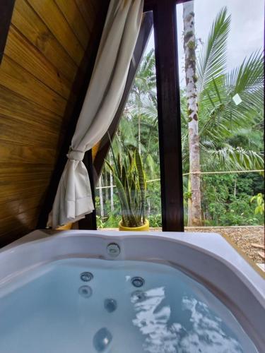 a bath tub in a room with a window at Chalé a 500 metros do Pico Malwee in Jaraguá do Sul