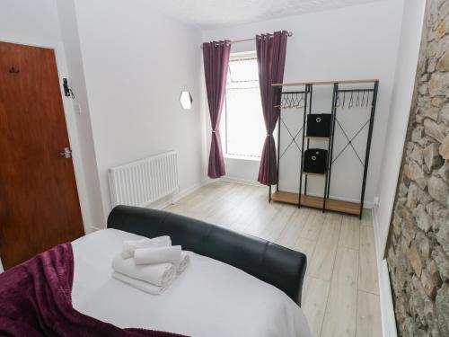 a bedroom with a bed with two towels on it at Brynawel in Burry Port