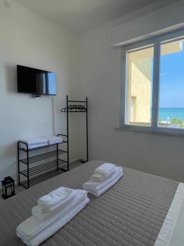a white room with a bed with towels on it at La Perla Saba 2 in Montemarciano