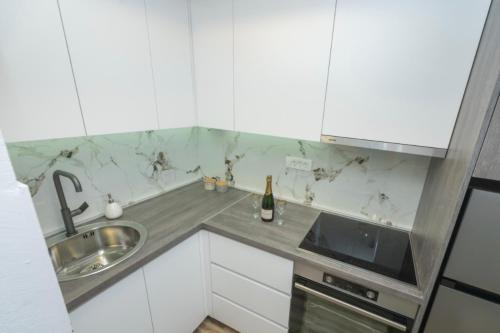 a kitchen with white cabinets and a sink at Apartment Center in Kolašin
