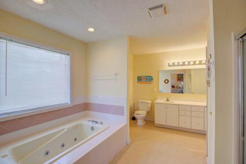 a bathroom with a tub and a sink and a toilet at NTBHC636 Whale Den in North Topsail Beach