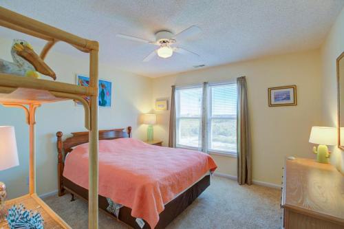 a bedroom with a canopy bed and a window at NTBHC636 Whale Den in North Topsail Beach