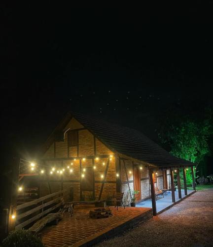 a wooden cabin with lights on it at night at Recanto Nascer do Sol in Nova Petrópolis