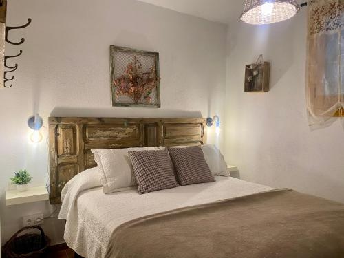 a bedroom with a bed with a wooden headboard at Villa Sanz in Cuenca