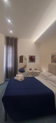 a bedroom with a large bed with a blue blanket at due stanzulelle sul mare B&B in Salerno