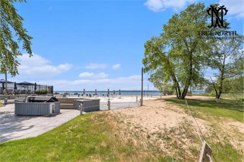 a park with a tree and a sandy beach at Beautiful Lake View Studio Condo at The Shores in Traverse City