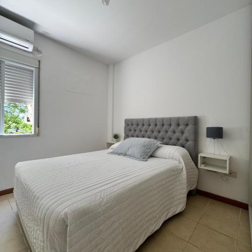 a bedroom with a large bed in a white room at Tu hogar en Resistencia, con cochera in Resistencia