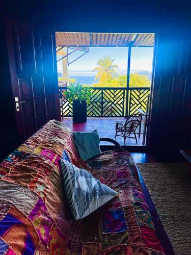 una camera da letto con un letto con vista sull'oceano di Hummingbird House a Calibishie