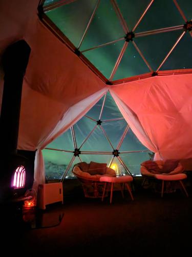 a room with two beds in a tent with a window at Skaland panorama in Senja