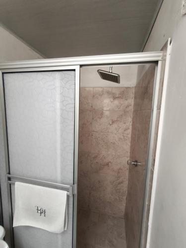 a shower with a glass door in a bathroom at Denier House Guabinal - Cerca de Centros Comerciales in Ibagué