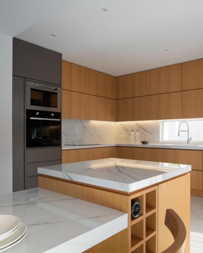 a kitchen with wooden cabinets and a white counter top at Villa Kalliston - 4000m2 of Elevated Living in Rethymno