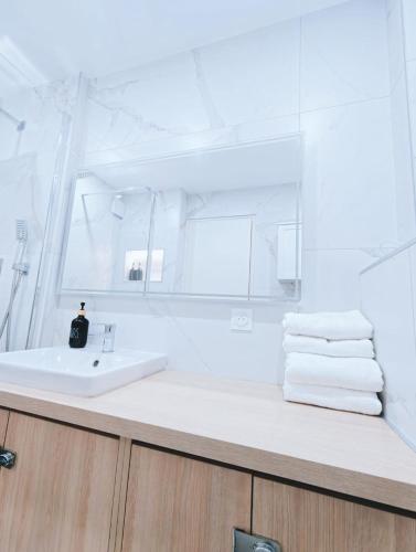 a white bathroom with a sink and a mirror at Ocean Bleu Toulouse in Toulouse