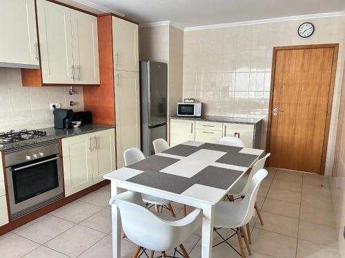 a kitchen with a black and white table and chairs at Ramalho Apartments T3 Cidade Ponta Delgada in Ponta Delgada