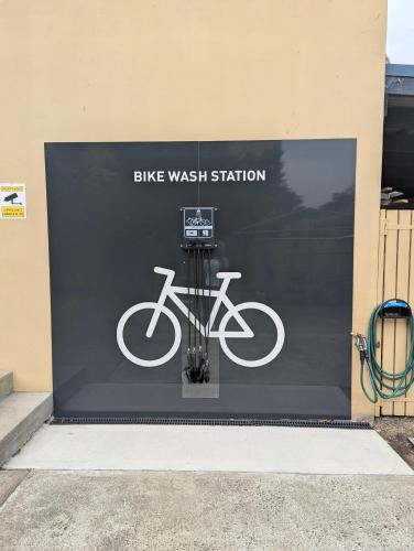 a sign for a bike wash station on the side of a building at Araluen Motor Lodge in Batemans Bay