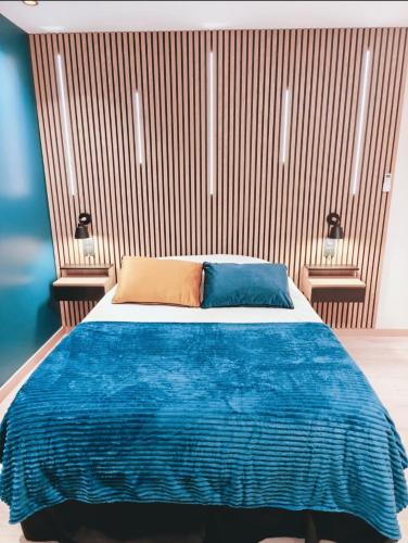 a bedroom with a blue bed with two pillows at Ocean Bleu Toulouse in Toulouse