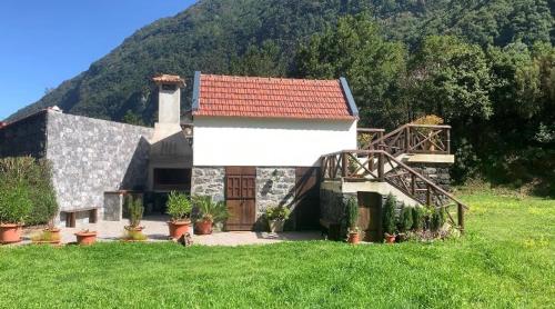 a house with a red roof on a green field at Mountain View Cottage in Seixal