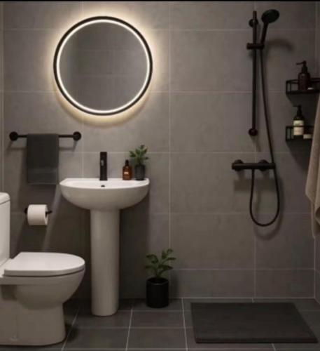 a bathroom with a toilet and a sink and a mirror at Deem view in Al Ain