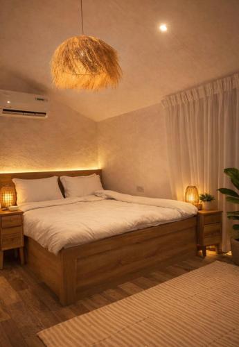 a bedroom with a large bed and a chandelier at Deem view in Al Ain