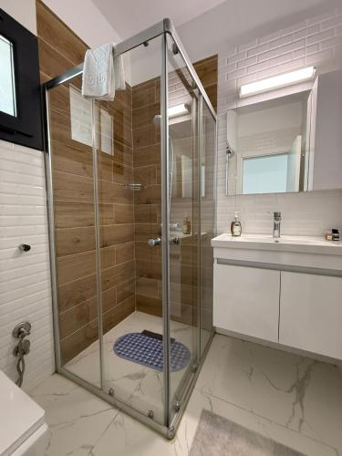 a bathroom with a glass shower and a sink at Caesar Resort & SPA & Apartments Spacious Studio in Avgorou