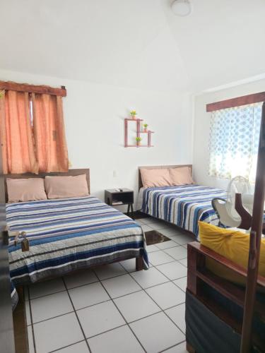 a bedroom with two beds and a window at Cómoda habitación Mar in Veracruz