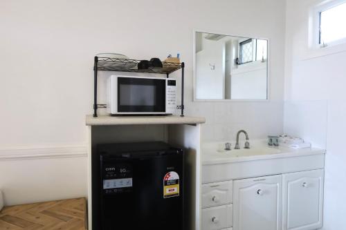 a kitchen with a black refrigerator and a microwave at Park Avenue Hotel Motel in Rockhampton