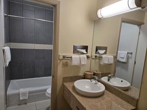 a bathroom with a sink and a toilet and a tub at Travelers Lodge Marshall in Marshall