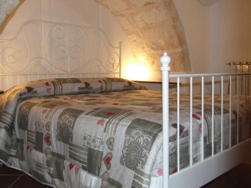 a bedroom with a white bed with a quilt on it at Dimora del Sole in Putignano