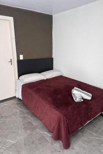 a bedroom with a bed with a red blanket at Apartamento com Custo Benefício Imbatível in Passo Fundo