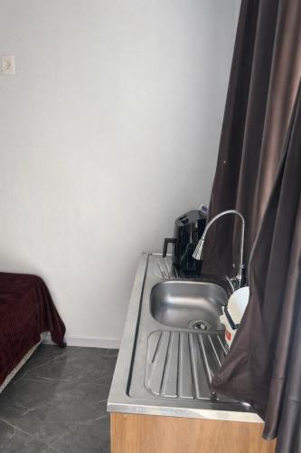 a sink in a room with a curtain around it at Apartamento com Custo Benefício Imbatível in Passo Fundo