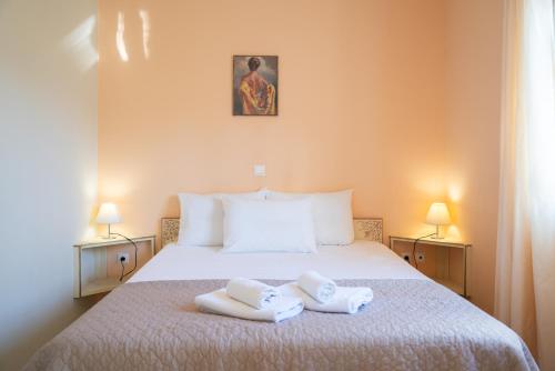 a bedroom with a bed with two towels on it at Casa Carina in Lakíthra