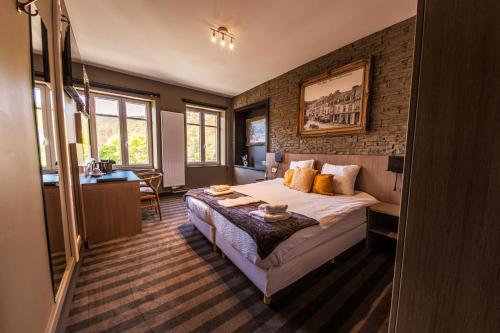 a hotel room with a bed and a desk at Le Palmarès Spa in Spa