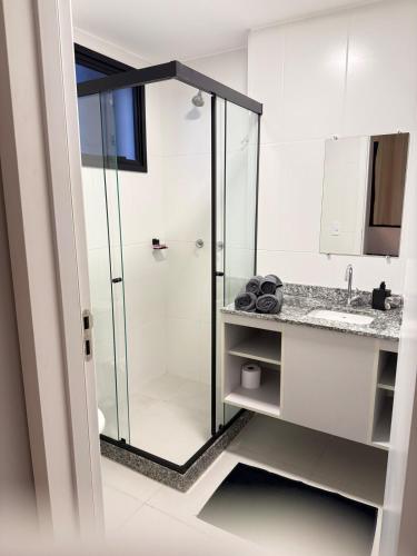 a bathroom with a glass shower and a sink at SeuLoft 110SouMais in Niterói