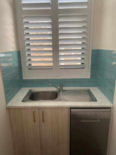 a small kitchen with a sink and a window at Belmore Living in Goulburn