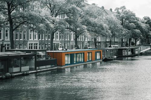 a house boat on a river in a city at The Amsterdam Houseboat Family - de Jordaan Brand New Houseboat! in Amsterdam