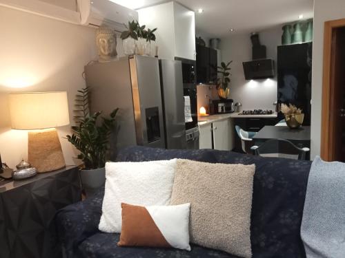 a living room with a blue couch and a kitchen at Alojamento do Canto in Viana do Castelo