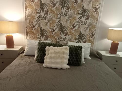 a bed with a white pillow on it with two lamps at Alojamento do Canto in Viana do Castelo