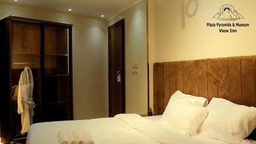 a bed with white sheets and pillows in a room at Giza Pyramids& GYM View in Cairo