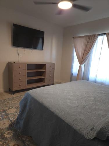 a bedroom with a bed and a flat screen tv at Twin Nest Duplex in Irving