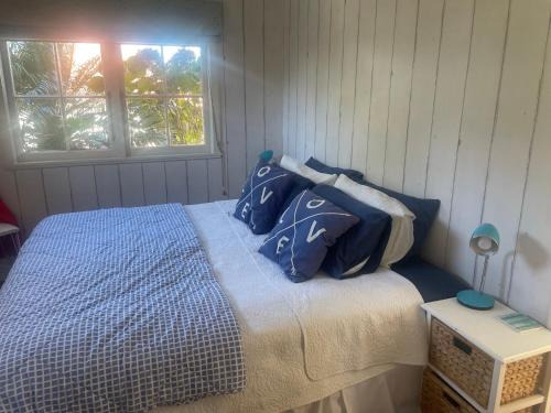 a bedroom with a bed with blue and white pillows at Bosuns Locker in Auckland