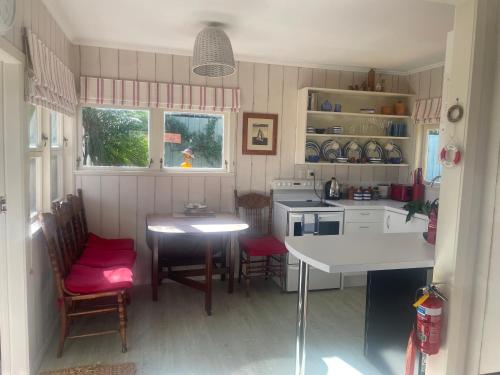 a small kitchen with a table and chairs and a table and a tableablish at Bosuns Locker in Auckland