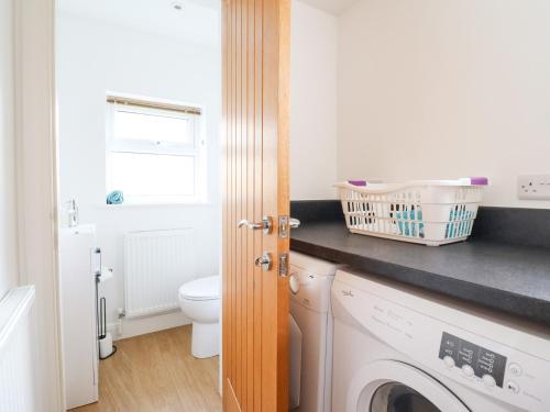 a bathroom with a washing machine and a toilet at Arnant in Dolgellau
